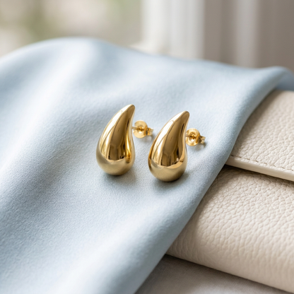 Teardrop earring pair on pale blue satin