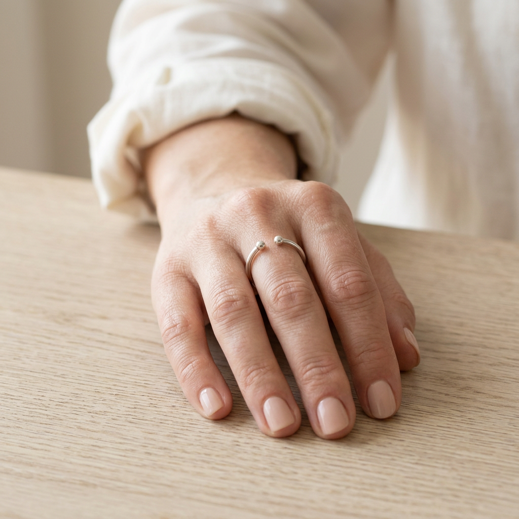 Model hand wearing open ring with white cotton shirt cuff