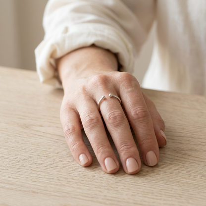 Model hand wearing open ring with white cotton shirt cuff