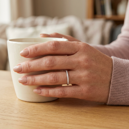 Model hand wearing delicate band ring with dusty-rose knit cuff