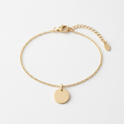 Fine gold-tone chain bracelet with smooth disc on white