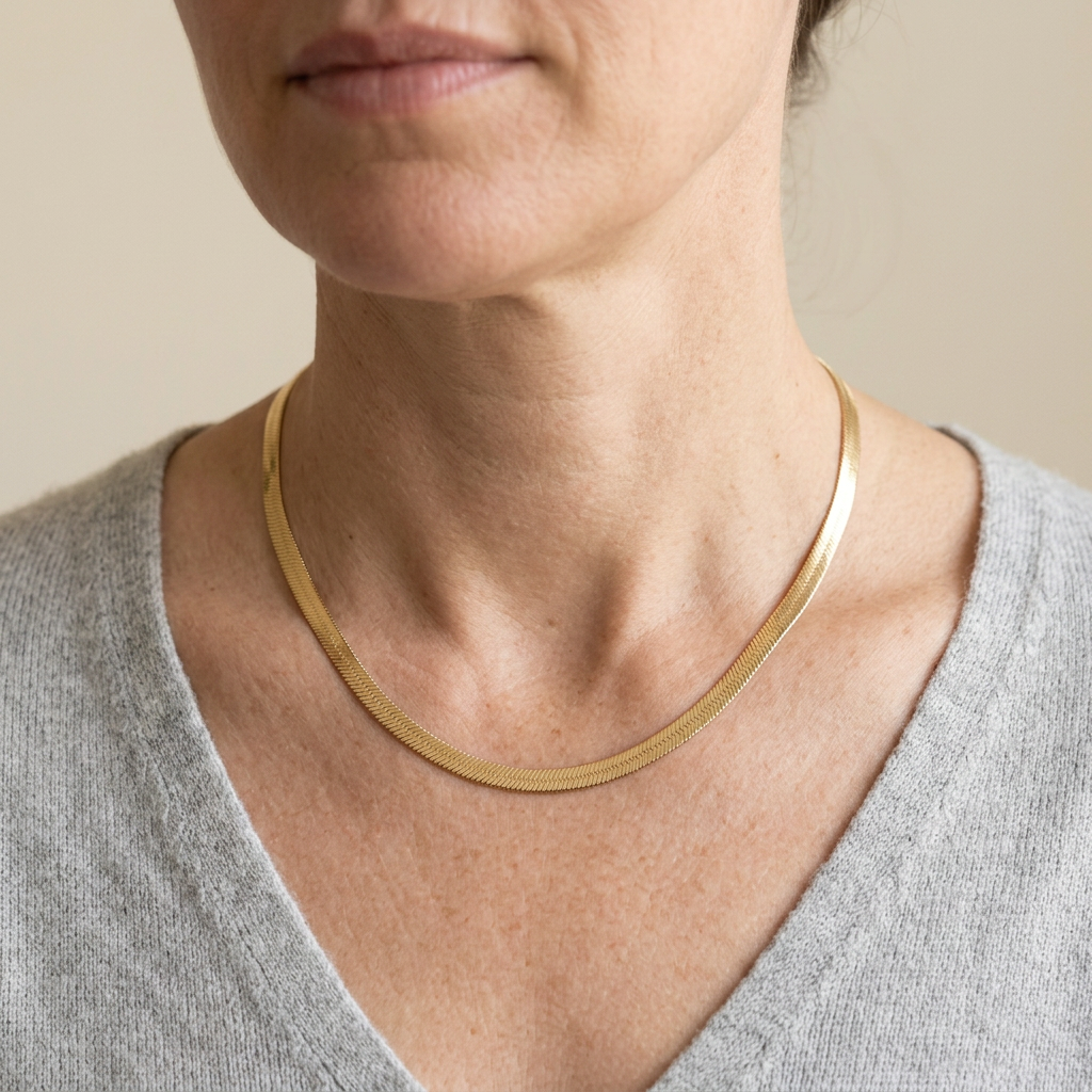 Model wearing herringbone necklace with light grey V-neck top