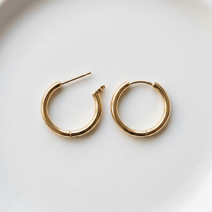 Matching gold-tone mini hoop earring pair on white
