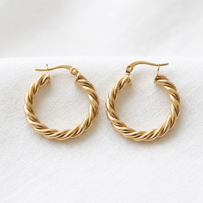 Matching gold-tone twisted rope hoop earrings on white