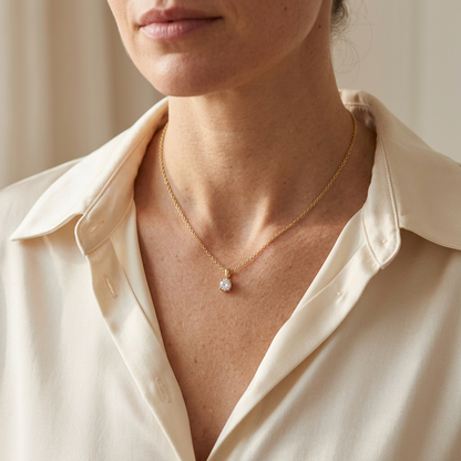 Model wearing solitaire necklace with cream satin blouse