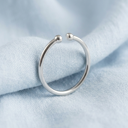Minimalist open ring on pale blue linen