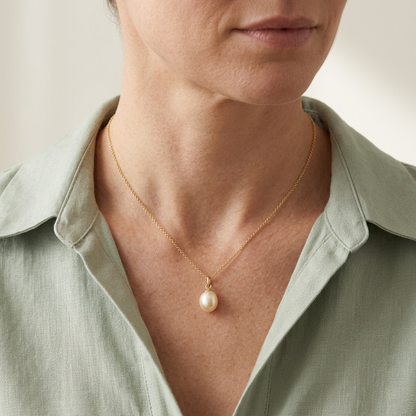 Model wearing pearl-style pendant with sage blouse