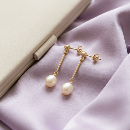 Pearl-style earrings styled on pale lavender satin