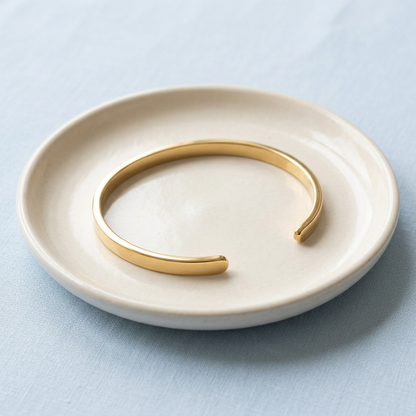 Open cuff on ivory ceramic dish