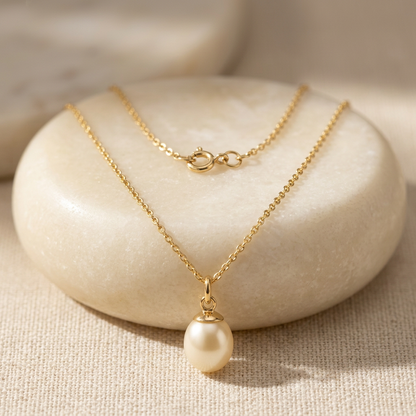 Pearl-style pendant necklace on an ivory stone pedestal