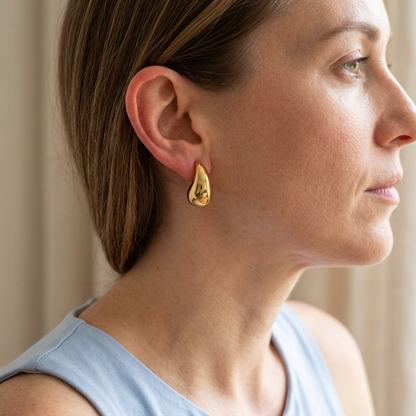 Model wearing teardrop stud earring with pale blue sleeveless top