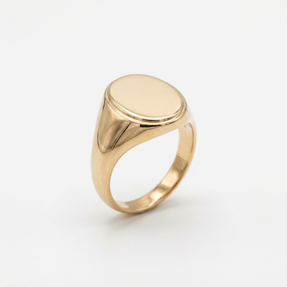 Gold-tone oval signet ring on white