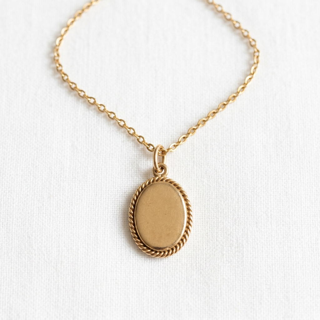 Gold-tone oval pendant necklace with rope-style border on white