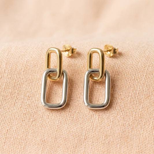 Two-tone earring pair on pale peach linen